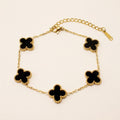 Black four leaf clover station bracelet in gold-tone stainless steel