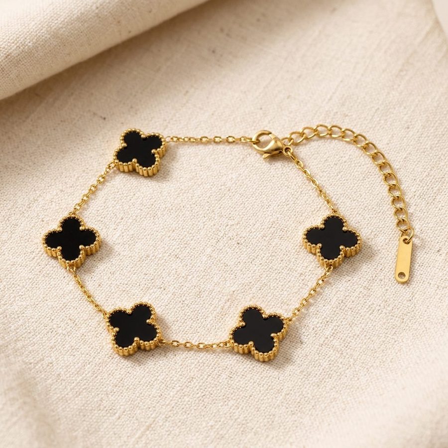 Black clover bracelet on warm linen