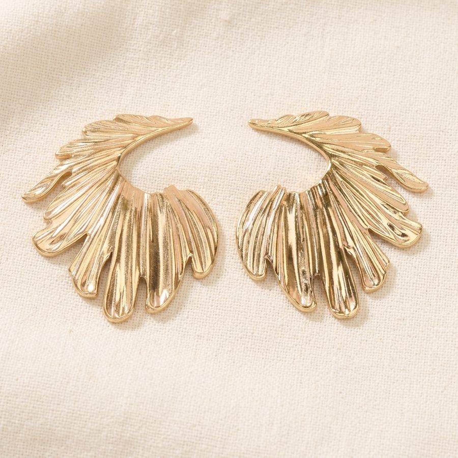Golden Wing earrings on cream linen