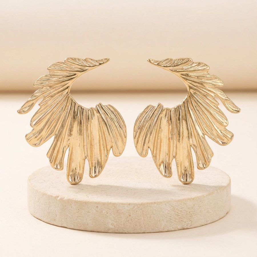 Golden Wing earrings on a stone riser