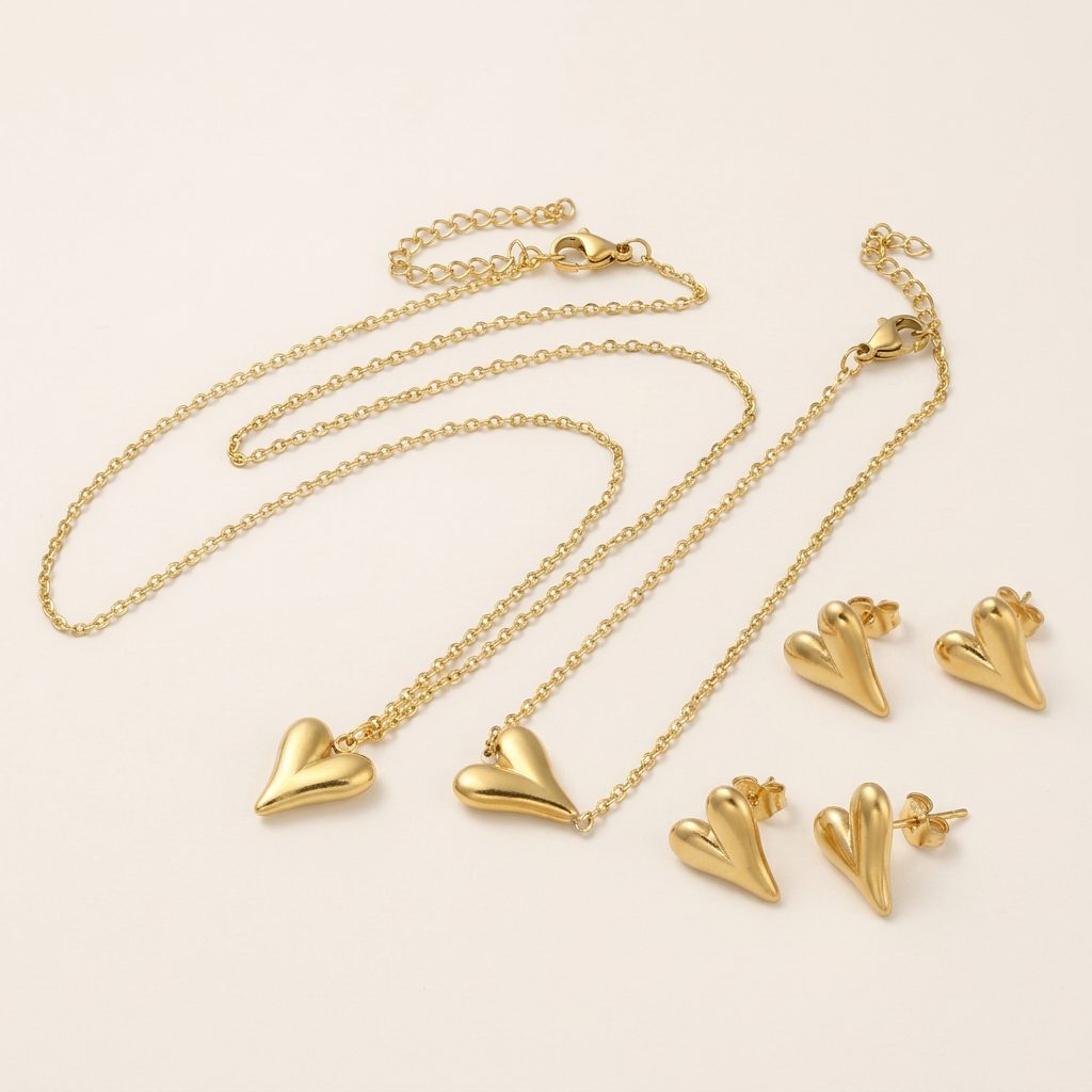 Styled flat lay of gold heart pendant and earrings set