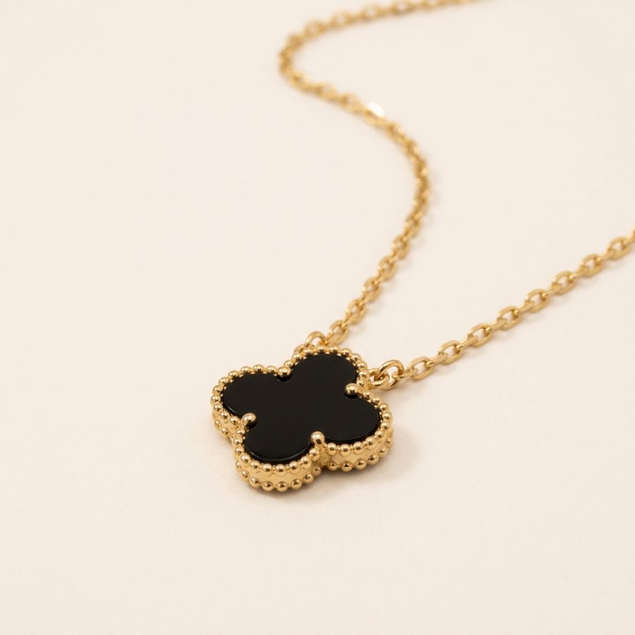 Black clover pendant and gold-tone chain close-up